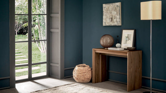 Goliath modern interior with a wooden console table against a blue wall, featuring decor items.