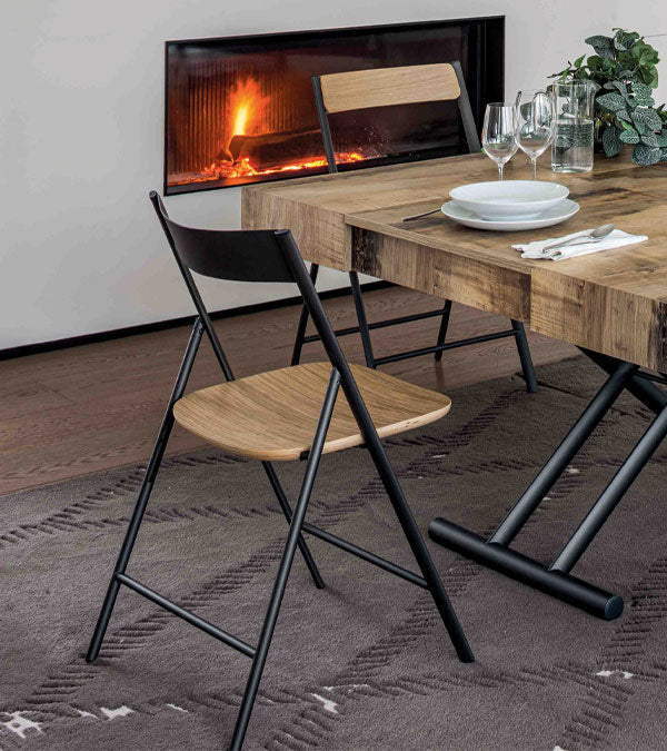 Dining table with Joe dining chairs in front of a fireplace