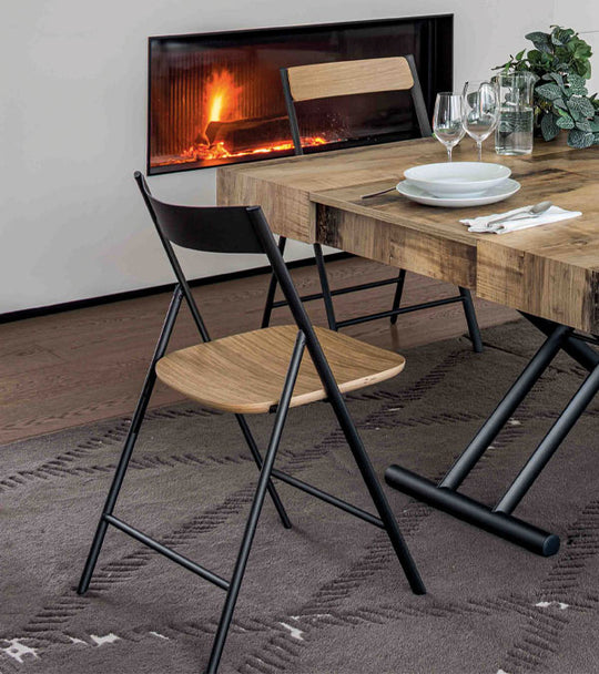 Dining table with Joe dining chairs in front of a fireplace