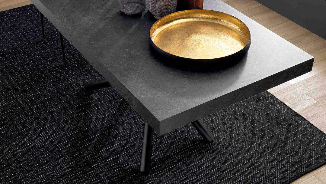London dining table, gold bowl on a black table with a textured black rug underneath