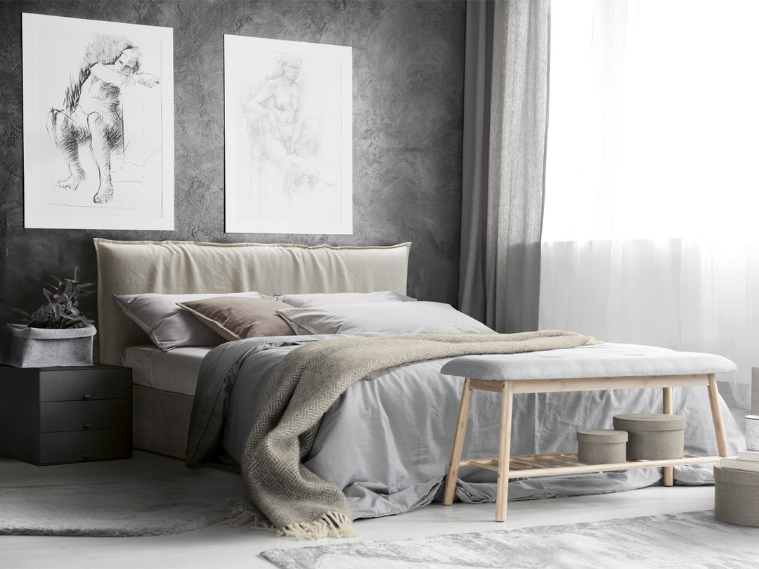 Naxos modern ottoman storage bed, nightstand, and bench against a gray wall with abstract art.