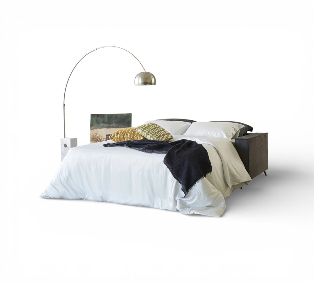 Mingus Sofa Bed with white bedding and a lamp on a white background
